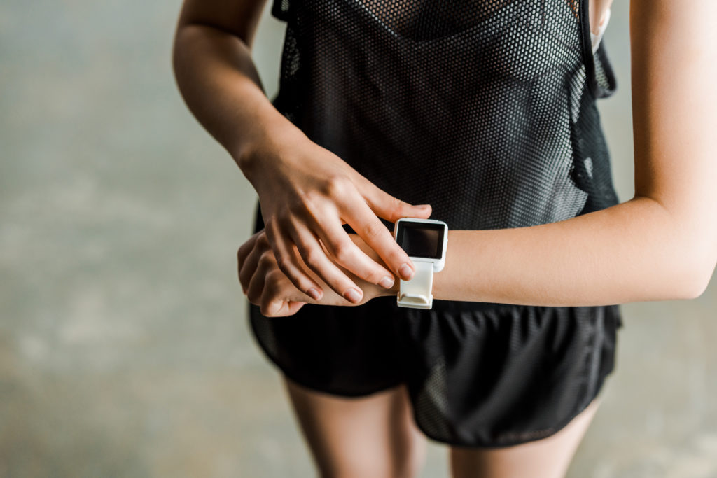 Woman checks a sports wearable watch or fitness tracker